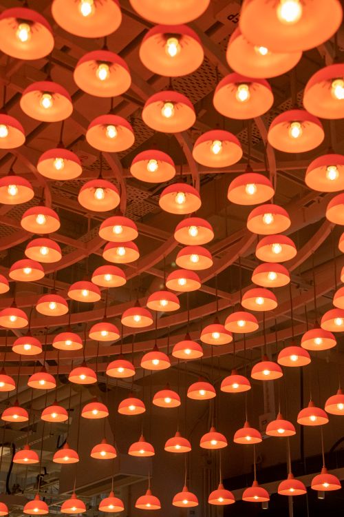 Free A mesmerizing arrangement of glowing orange pendant lights in an interior setting. Stock Photo