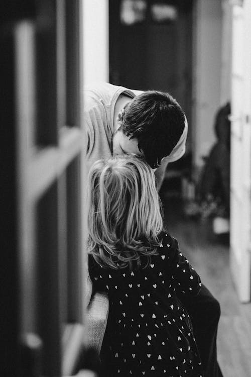 Monochrome Photo of a Father Kissing His Daughter