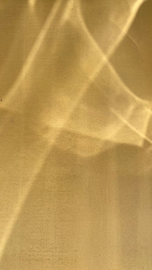 Free An artistic display of yellow light and shadow patterns on a textured wall surface. Stock Photo