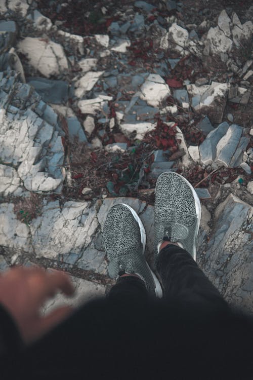 Photo of a Person's Feet Near Rocks