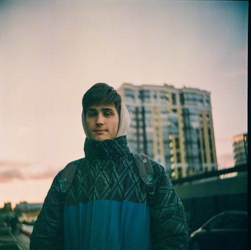 Man Wearing a Jacket and Carrying a Backpack