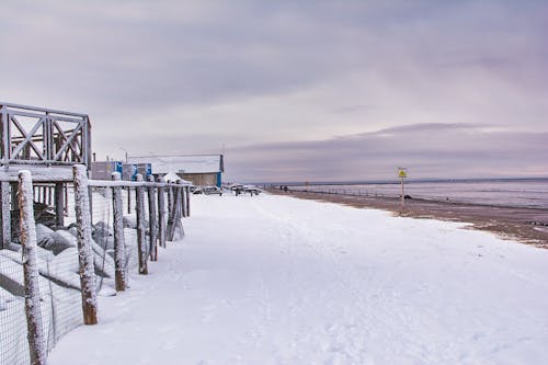 Snow Covered Sea Shore Under Cloudy Sky