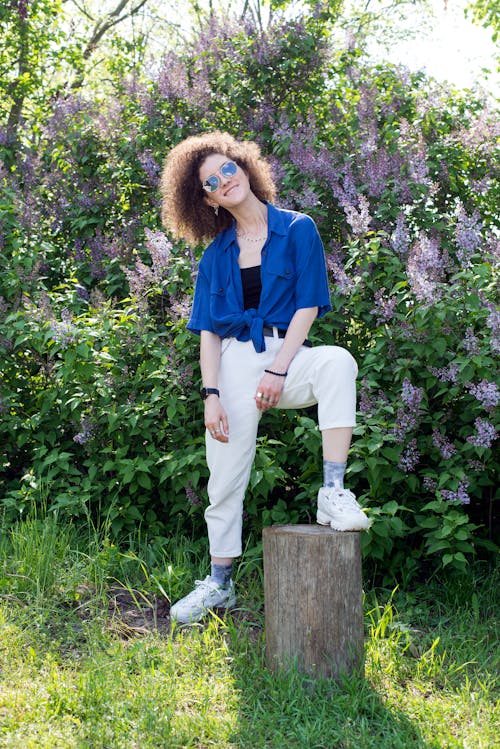 A Woman in Blue Blouse and White Pants 