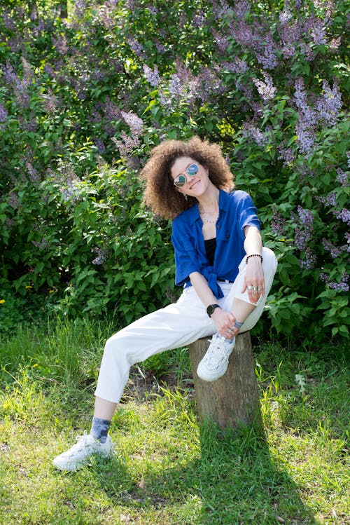 Photo of a Woman in a Blue Shirt Wearing Sunglasses