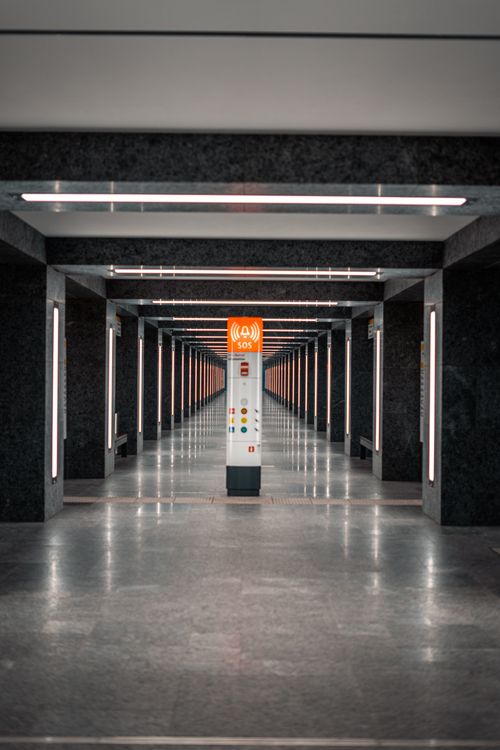 Free Symmetrical view of a modern subway hallway with an SOS post in the center. Stock Photo