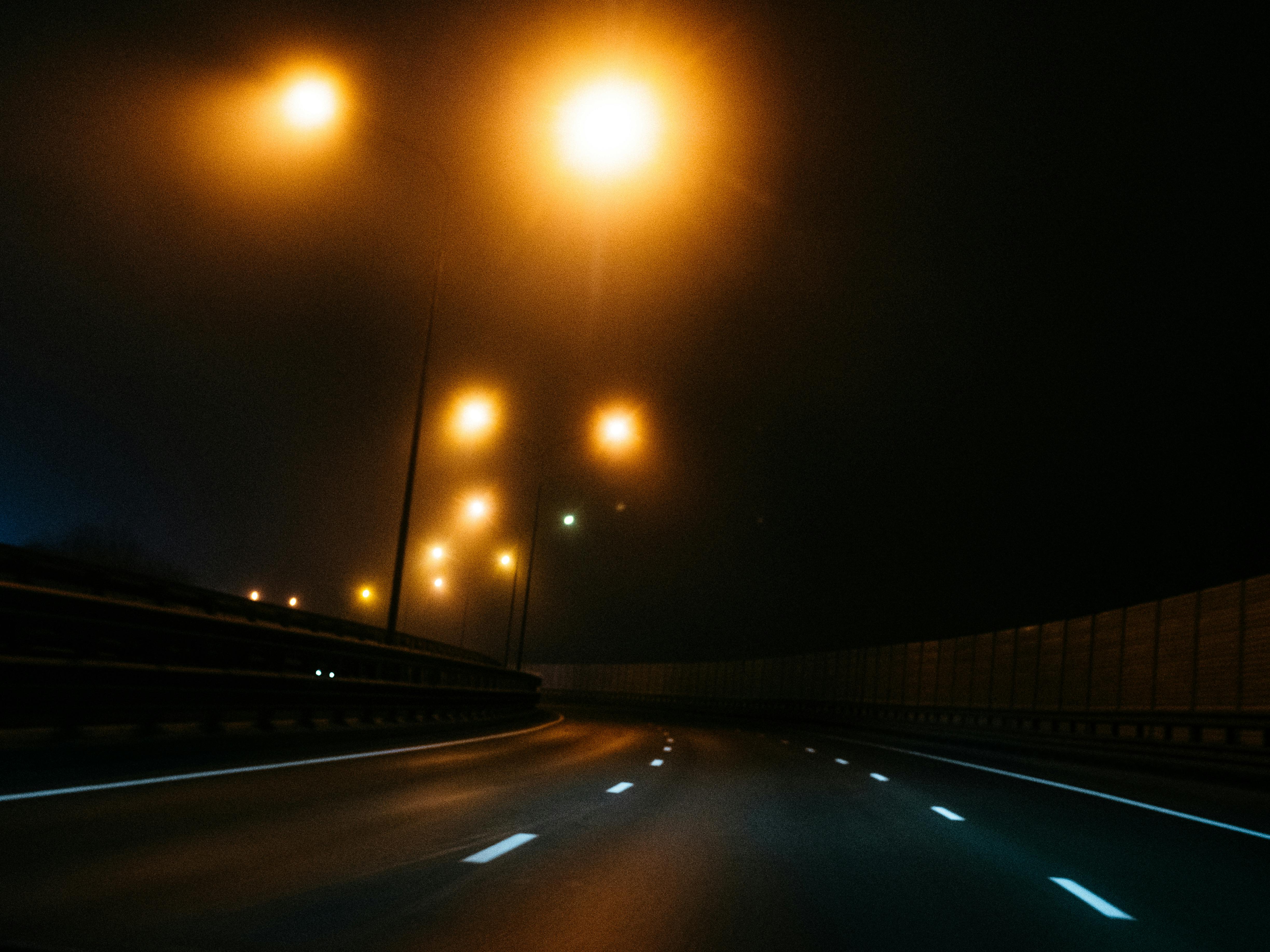 Wet Pavement Near Lighted Bridge · Free Stock Photo