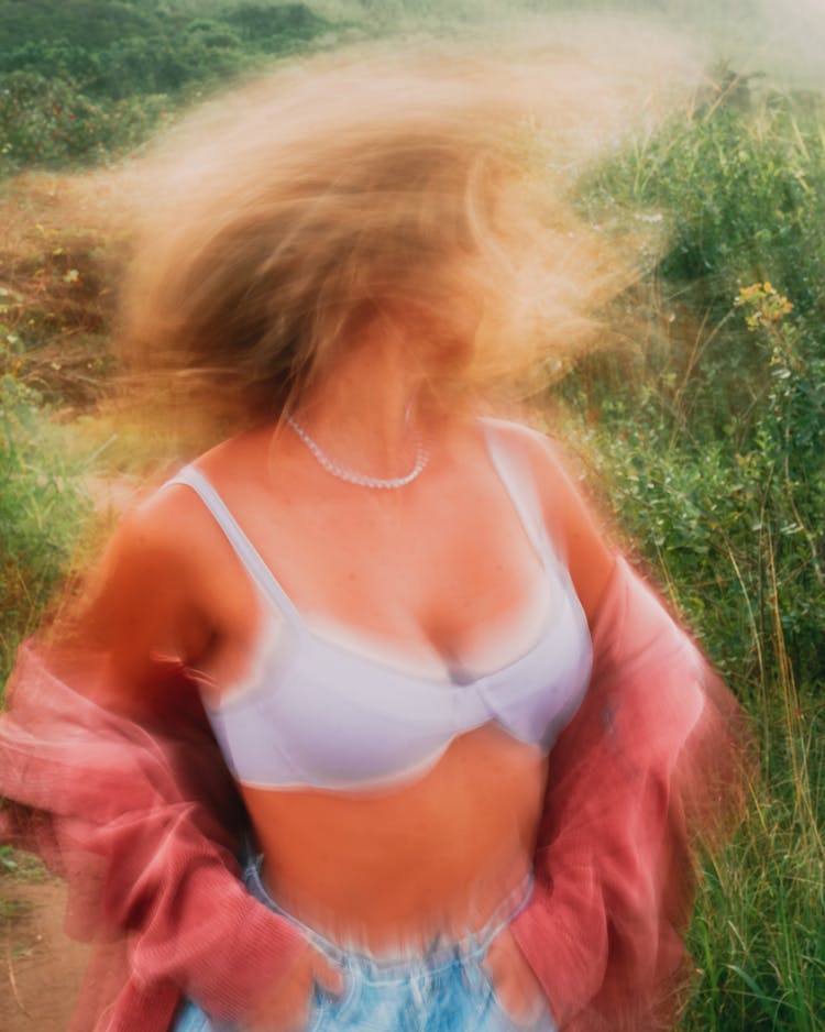 A Woman In White Brassiere Shaking Her Hair