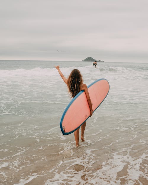 Free Photograph of a Woman Walking with Her Surfboard Stock Photo