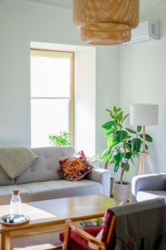 Bright living room with modern furnishings and lots of natural light streaming through a large window.