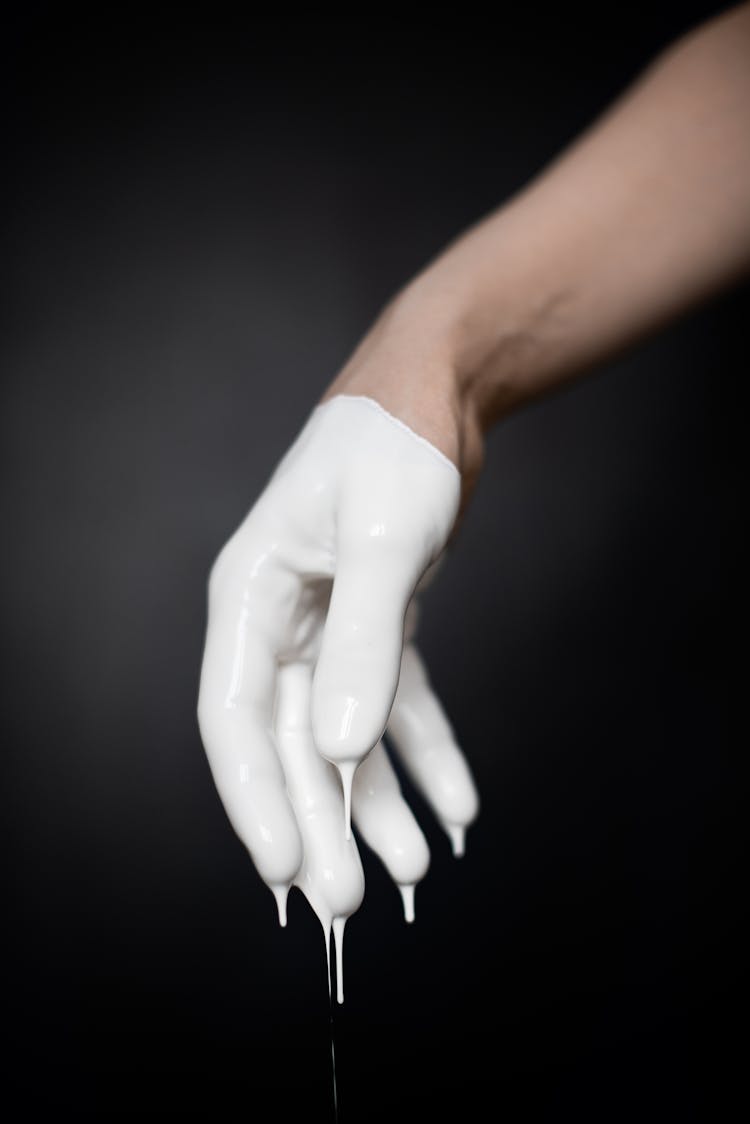 Hand Covered In White Paint On Black Background