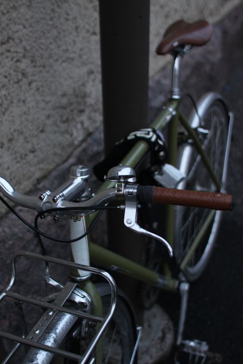 Free A classic styled bicycle parked on a city street against a textured wall. Stock Photo