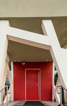 引人注目的现代建筑入口处，有一扇大胆的红色门，由几何支撑框架构成