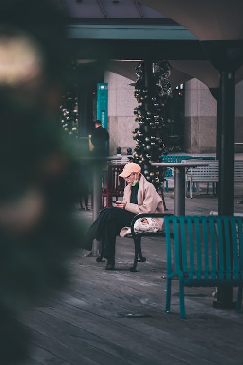 Free Man in Brown Coat Sitting on a Bench Stock Photo