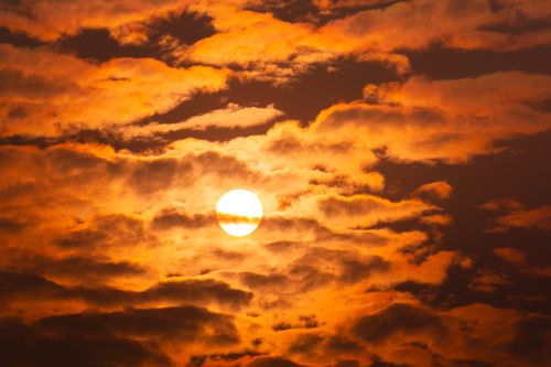 Free Dramatic sunset with golden clouds and bright sun over India, capturing a serene skyscape. Stock Photo