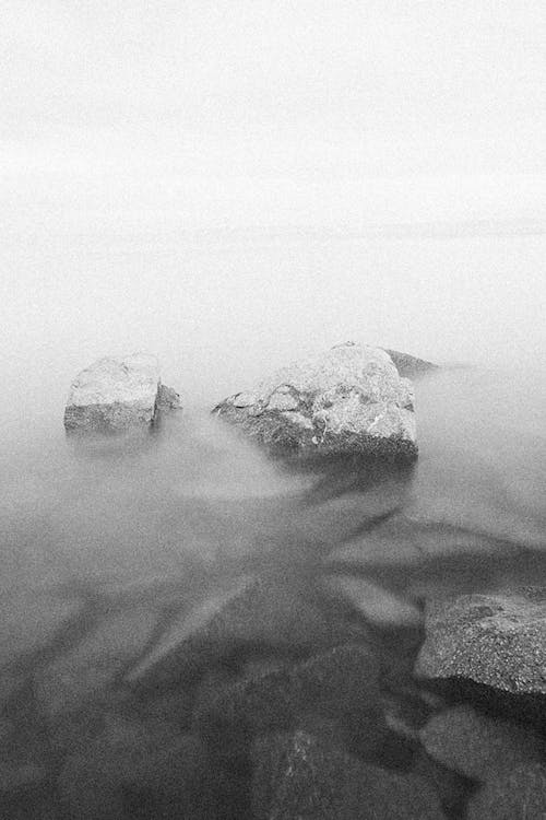 Boulders of Rocks on the Lakeside in Black and White Photo