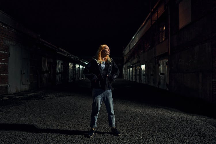 Woman Standing On A Street At Night 