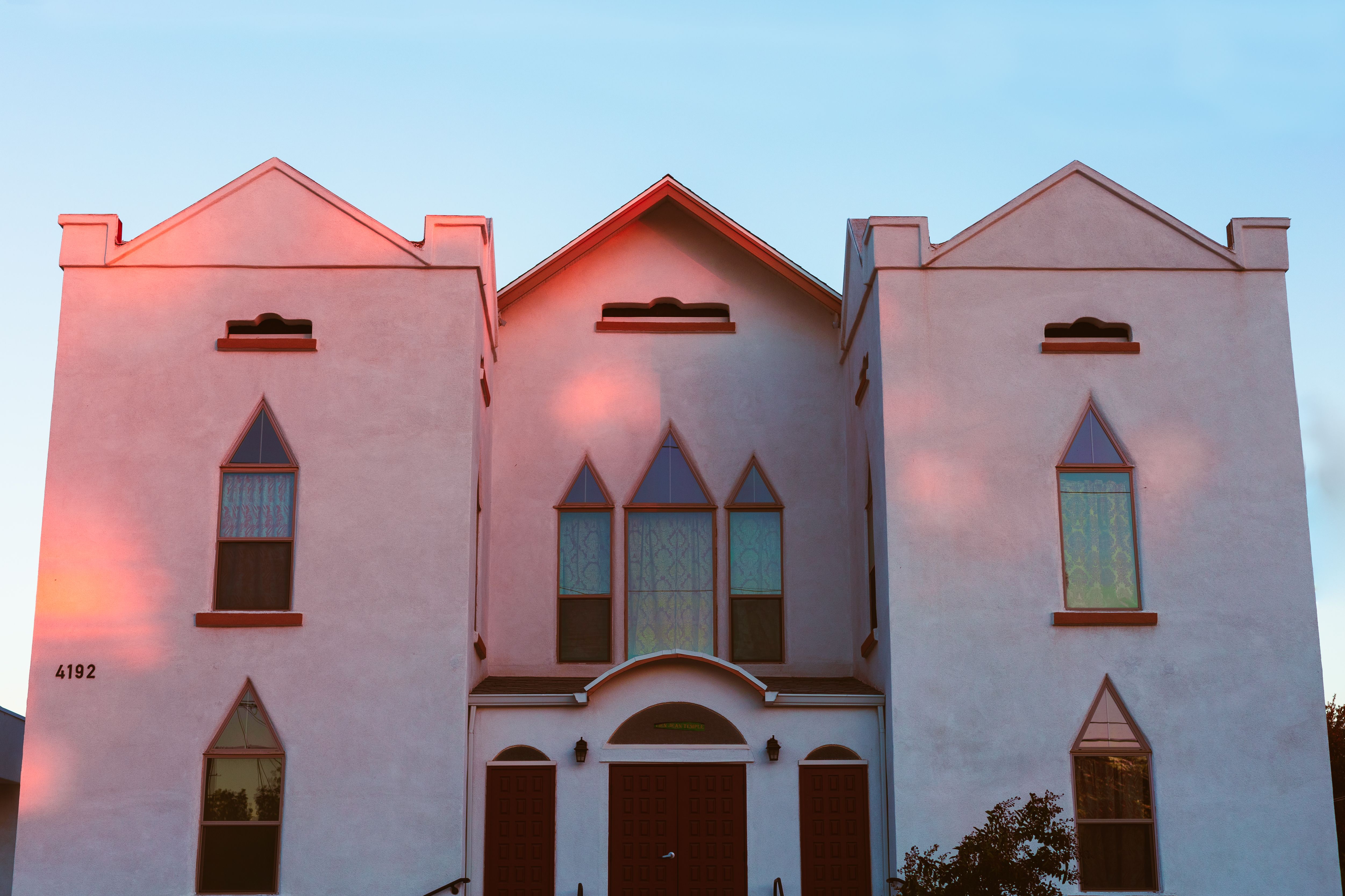 A contemporary building facade captured at sunset showcasing geometric windows and unique design.