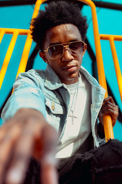 Photo of a Man in a Denim Jacket Wearing Sunglasses