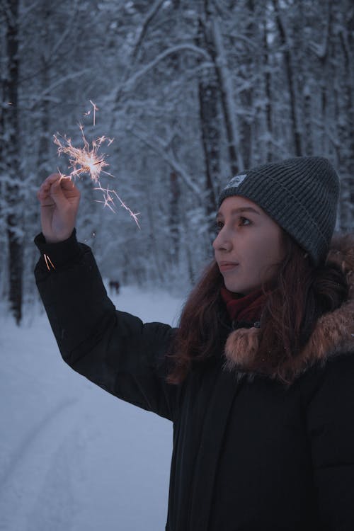 Photo of a Teenager Holding a Sparkler