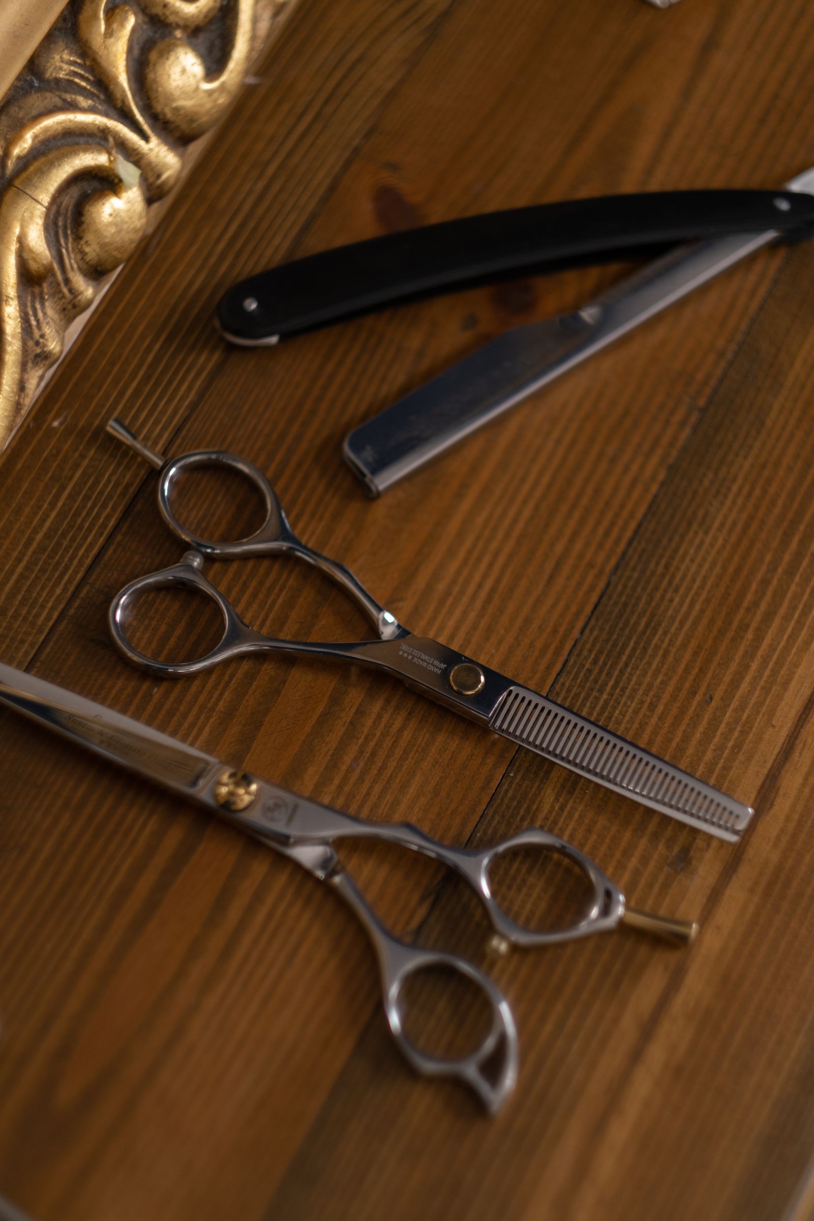Ciseaux et outils de coiffure artisanaux, détail chaleureux bois et métal