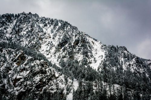 Free Dramatic snow-covered mountains under a gray winter sky. Stock Photo