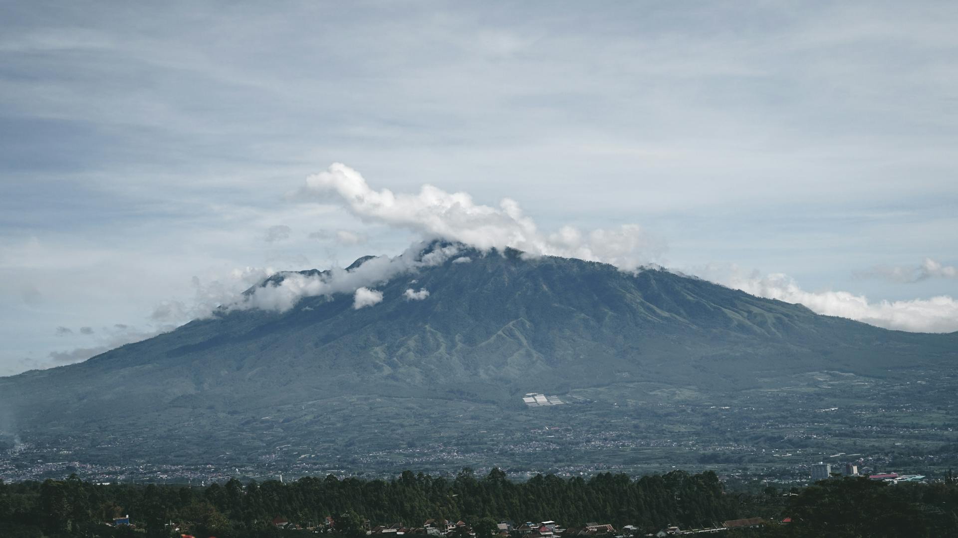 Scenic view of Mount Arjuno surrounded by clouds near Malang, East Java, Indonesia.