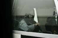 在埃及开罗，一名妇女在车里等候，透过车窗倒影