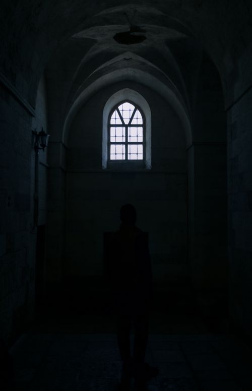Free Silhouette of a person standing in a dark archway with a gothic window in Mardin, Turkey. Stock Photo