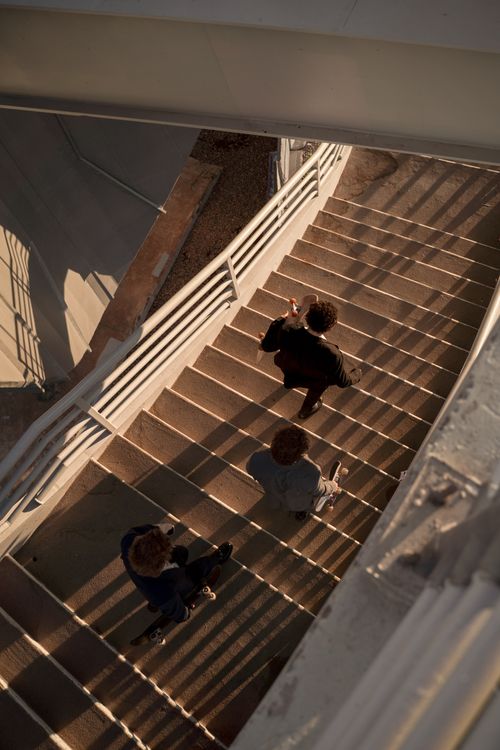 Free Urban staircase captured from above with three adults walking. Dynamic light and shadows. Stock Photo