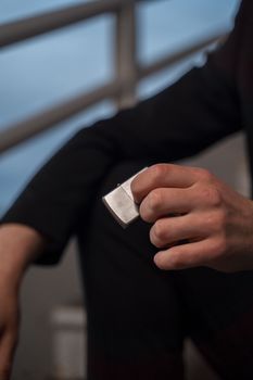 A close-up photo of a hand holding a metal lighter, featuring blurred background and black sleeves.