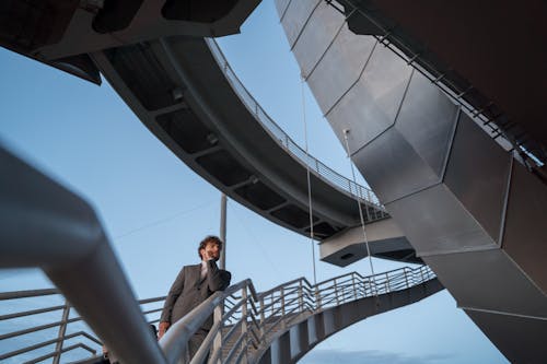 Low-Angle Shot of a Man in Gray Suit Standing on the Stairs