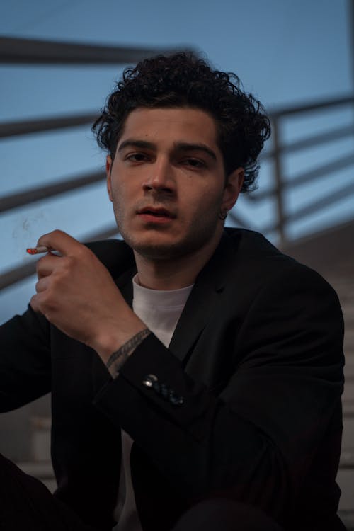 Portrait of a Man with Curly Hair Smoking a Cigarette