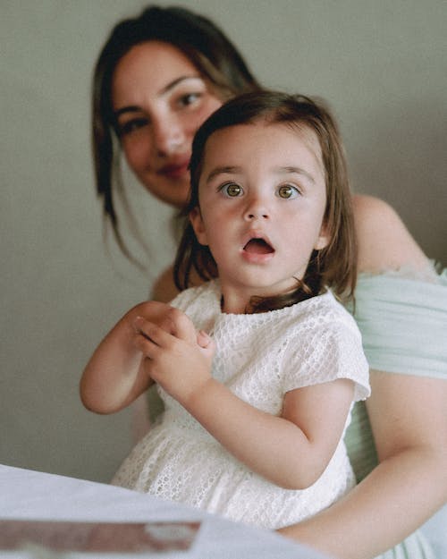 Photo of a Surprised Girl in a White Dress