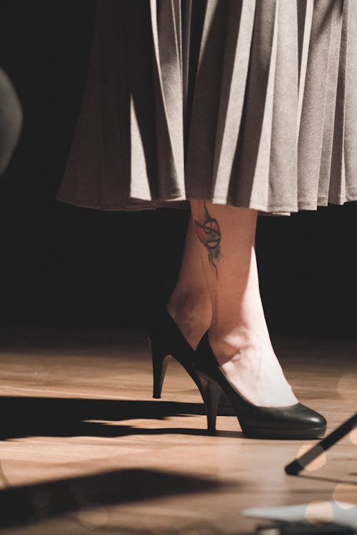 Free Woman in Black Heeled Shoes Standing on Brown Surface Stock Photo