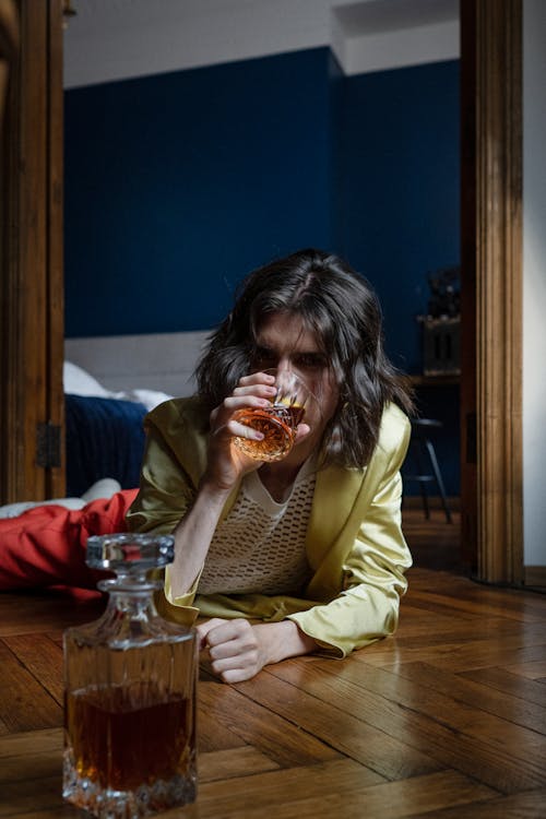 Man Laying on the Floor and Drinking Whiskey