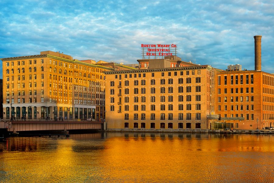 The Boston Wharf Co. building on Fort Point Channel, lit gold at sunrise