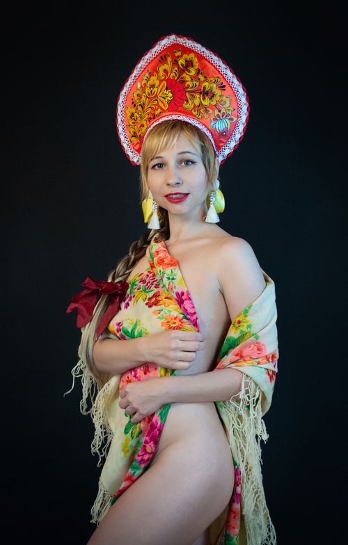 Free Portrait of a woman wearing traditional red floral headdress and shawl on black background. Stock Photo