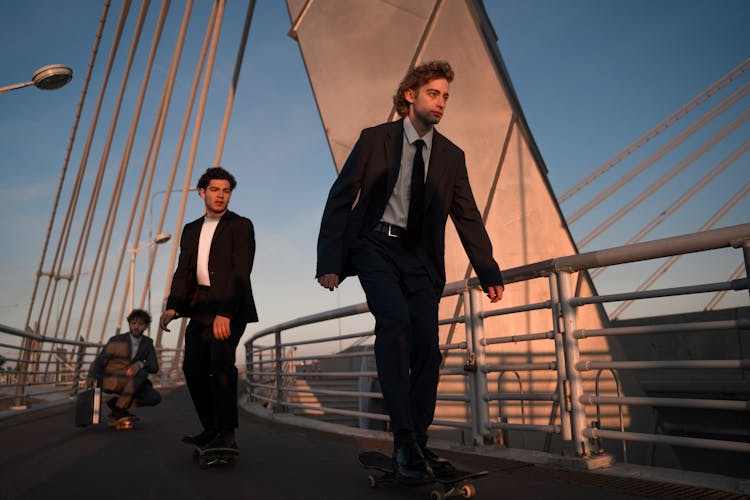 Three Men In Suits Skateboarding