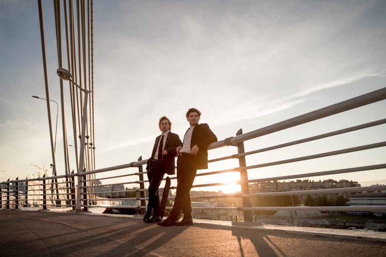 Two Men Standing On Bridge