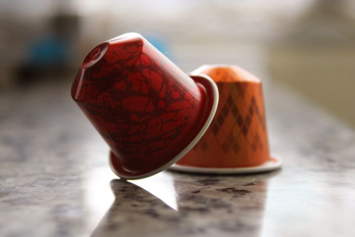 Coffee capsules on a marble counter — photo by Daniel Fontes on Pexels