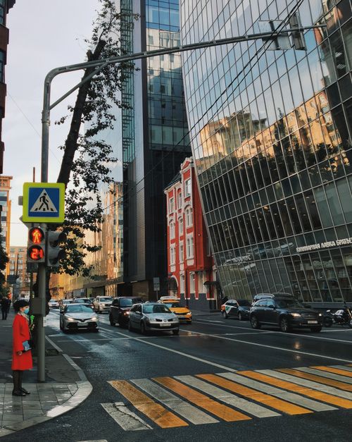 Free Street view in Moscow featuring modern architecture, traffic, and a pedestrian waiting to cross. Stock Photo