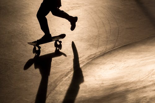 Silhouette of a Person on Skateboarding in a Skatepark 