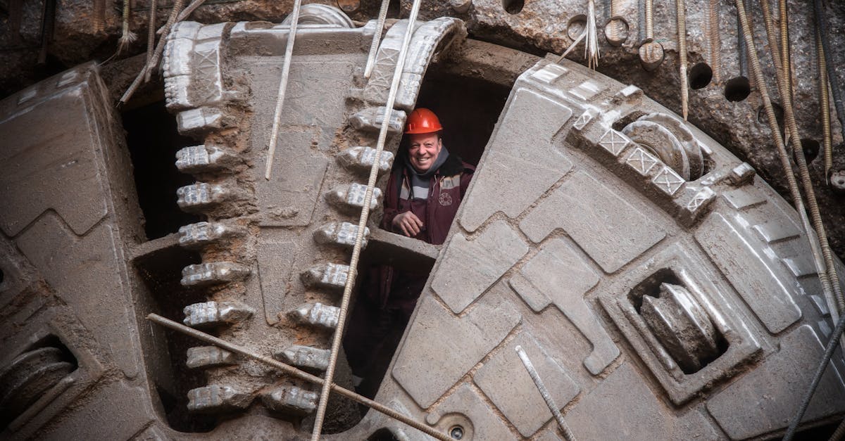 Photo by Max Mishin Construction worker stands inside massive tunneling machine in Moscow, Russia, showcasing industrial capability.