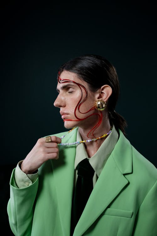 Androgynous Man Holding Necklace