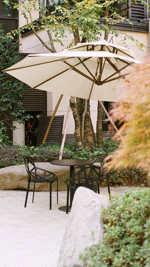 Black Metal Table With Chairs and Umbrella