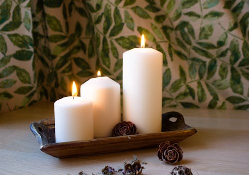 White Pillar Candles on Brown Wooden Tray