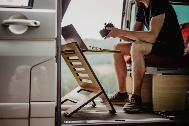 Man Sitting In A Van And Working On A Laptop 