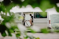 A Person Sitting Inside a Van in front of His Laptop while Looking Afar