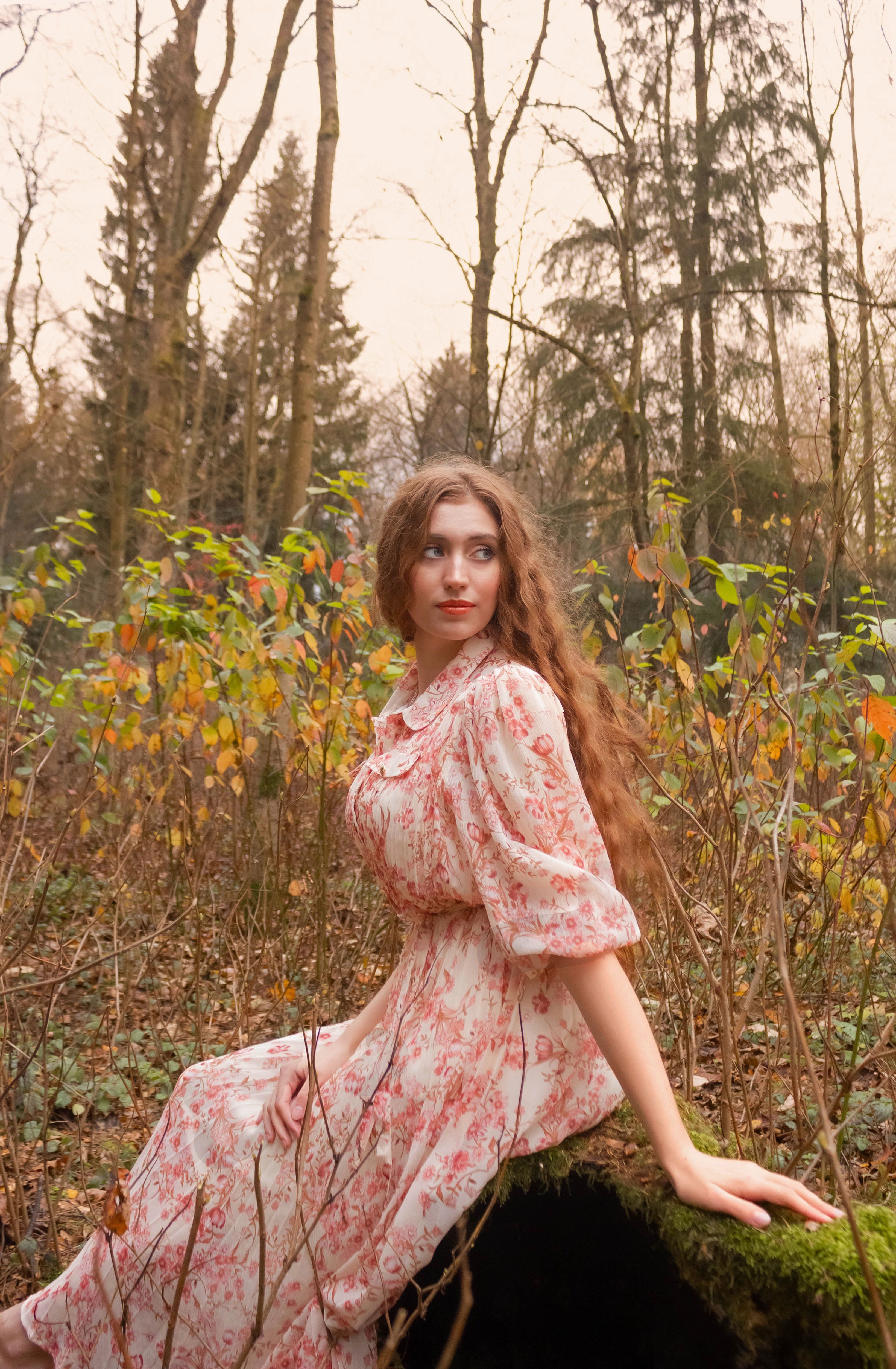 Woman in Floral Dress Sitting on a Mossy Rock · Free Stock Photo
