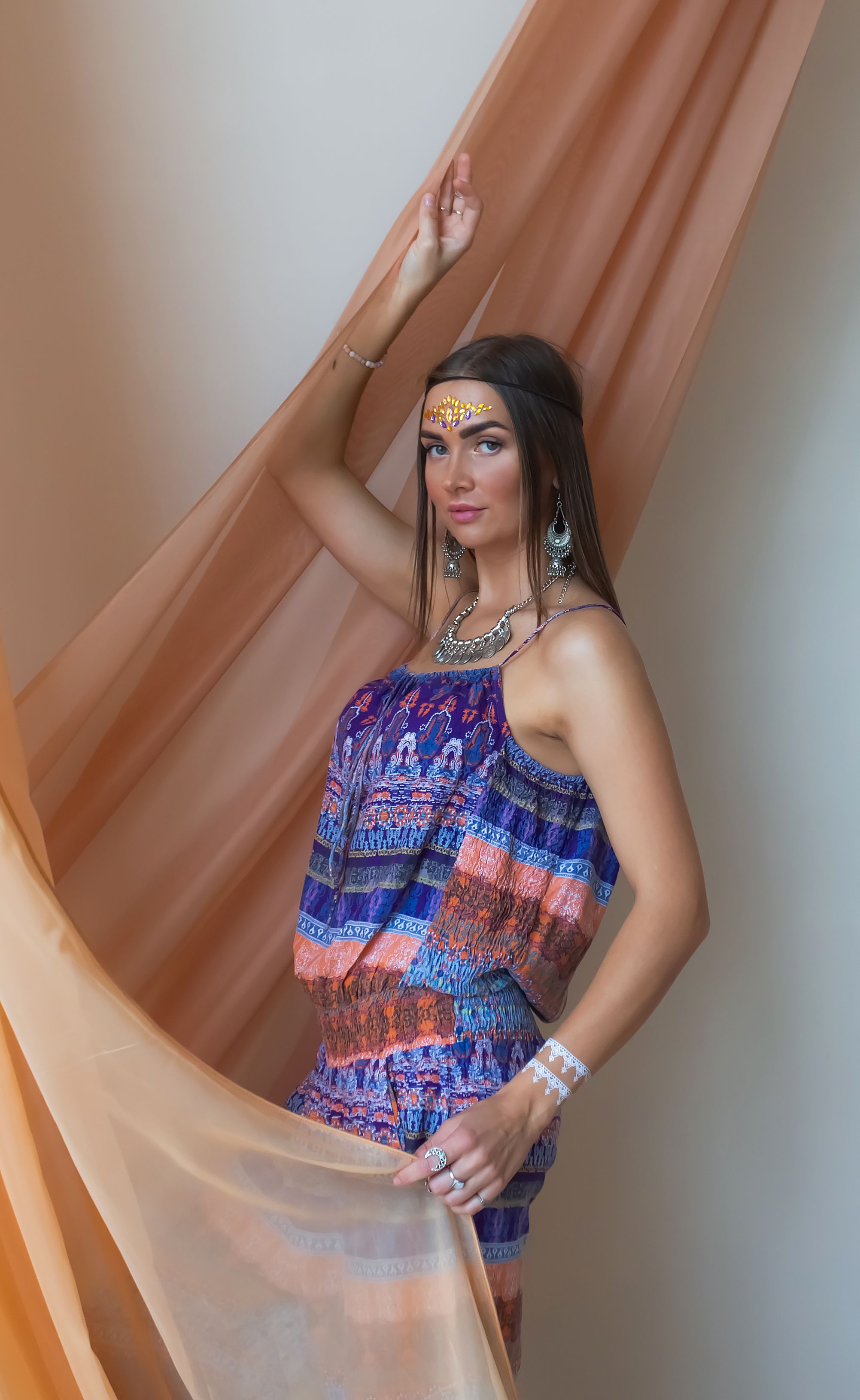 Retrato de uma mulher com moda boêmia, maquiagem artística e joias.